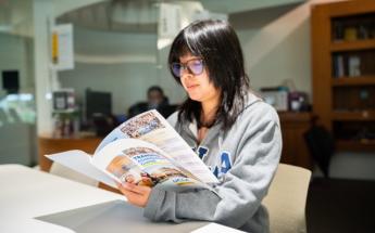 College student reading a UCLA brochure