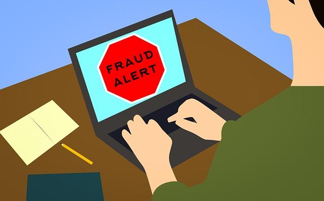 A graphic of a man on a computer using a laptop on a desk. The laptop screen reads "FRAUD ALERT".