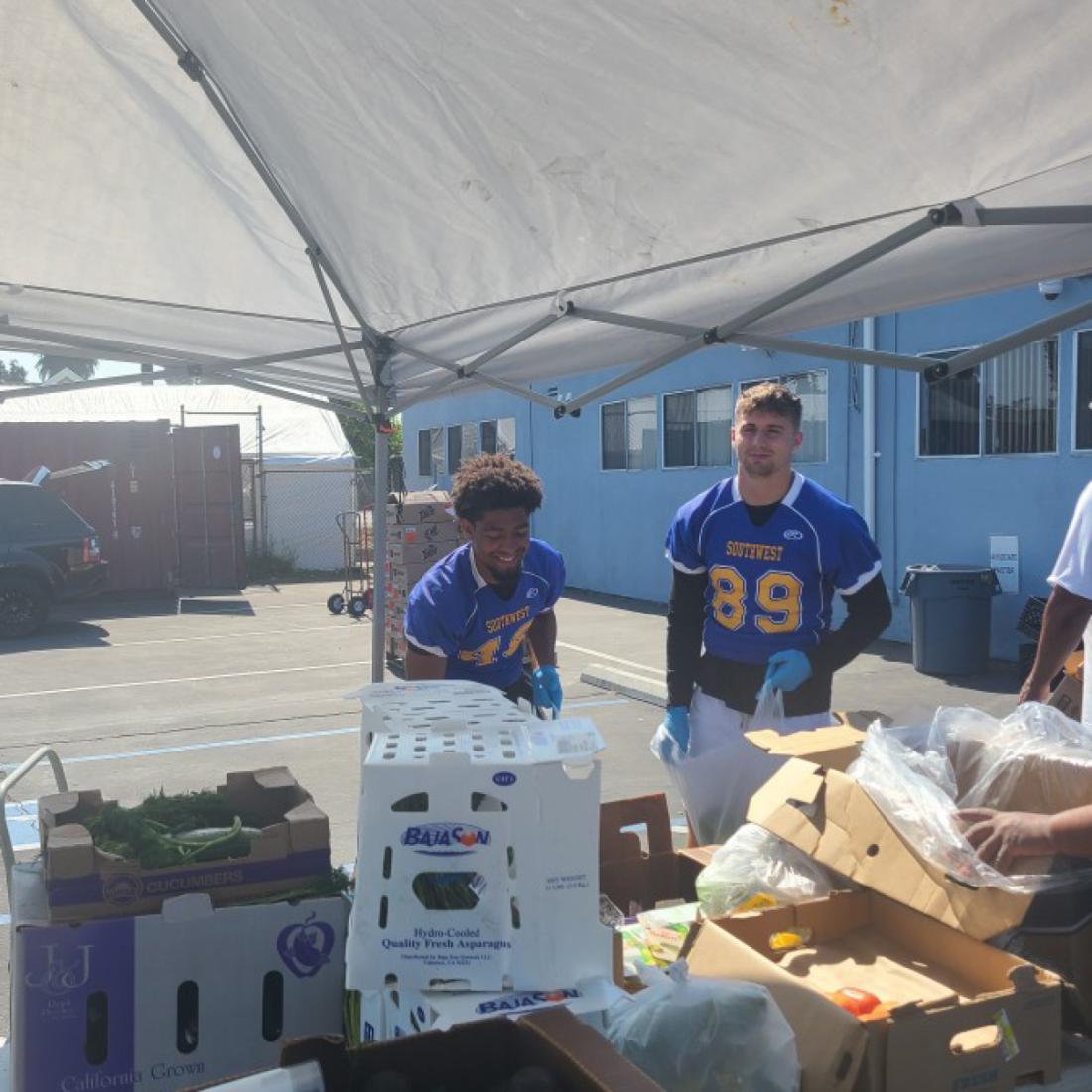 LASC Cougar Football team passing out food to those in need at The Great Grocery Giveaway