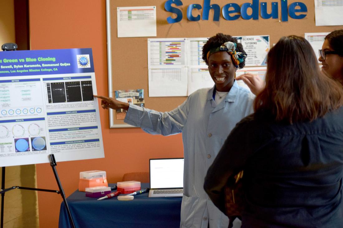 A STEM student presenting their research to an interested audience