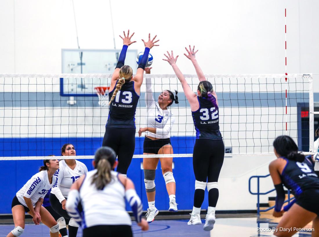 Two Los Angeles Mission College Volleyball players blocking the shot of an opponent.